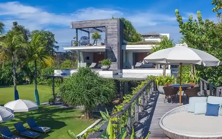 Beachfront villa with a pool, lawn and sun loungers in Bali