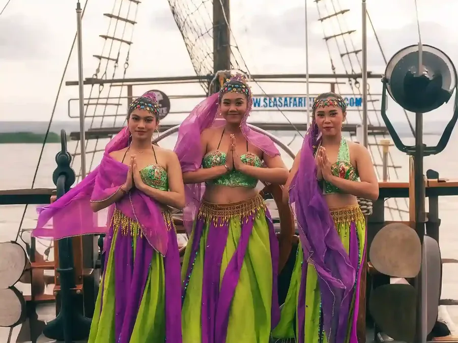Balinese dancers performing on the deck of a charter at night