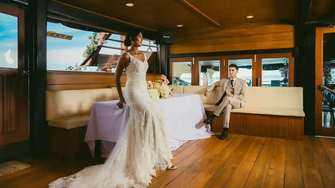 Bride and groom at a table set for a celebration aboard a charter in Bali