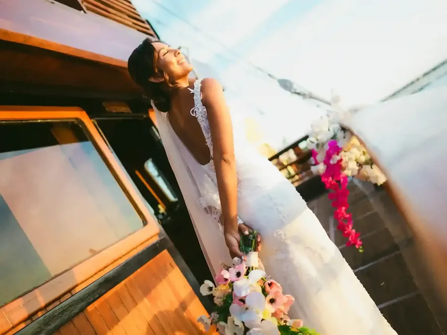 Bride with flowers beside the window of a charter in Bali