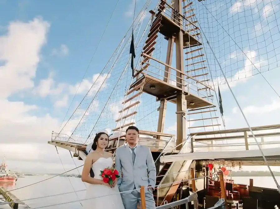 Couple with a bouquet aboard a traditional phinisi in Bali